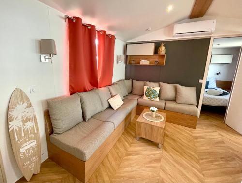 ein Wohnzimmer mit Couch und Tisch in der Unterkunft Mobil-home tout beau tout neuf, camping 4*, plage à pied ! in Canet-en-Roussillon