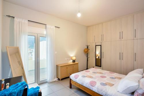 a bedroom with a bed and a large window at Souda apartment in Souda