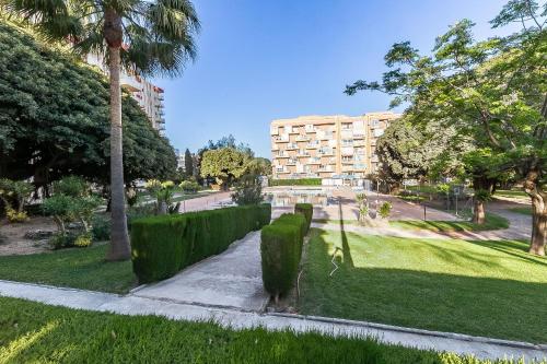 a park with a building and trees and a sidewalk at Sun Coast Benalmádena -- Superb studio with 4 pools, gardens & breakfast in Benalmádena