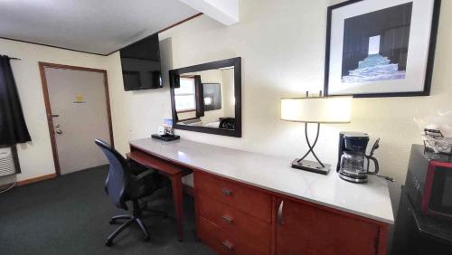 a hotel room with a desk with a lamp and a mirror at Hunter's Friend Resort on Indian Point in Branson