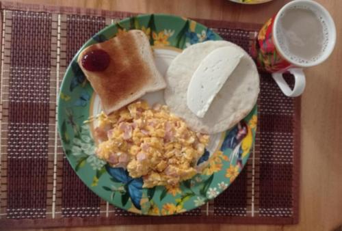 a plate of food with cereal and toast and a cup of coffee at Hotel Gio in Sonsón