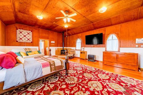 a bedroom with a bed and a flat screen tv at Gateway Cottage in Orick