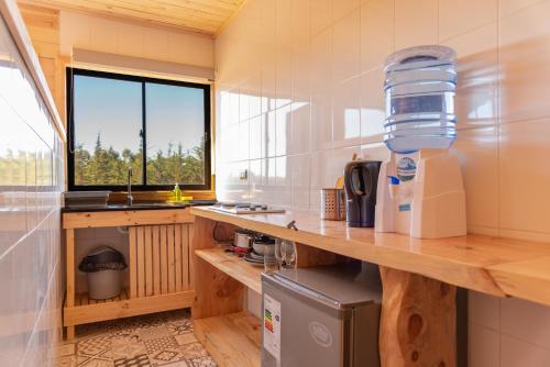 cocina con encimera, fregadero y ventana en 360 Lodge Pichilemu, en Pichilemu