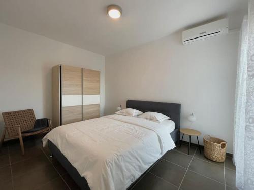 Un dormitorio con una gran cama blanca y una mesa en Appartement MB - Logement 3 chambres - Drage en Drage