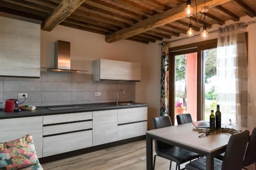 a kitchen with a table and a dining room at Agriturismo L'Aquilone in Magliano in Toscana