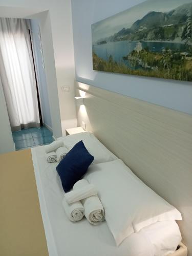 a room with a bed with towels and a painting at Borgo 800 in San Nicola Arcella