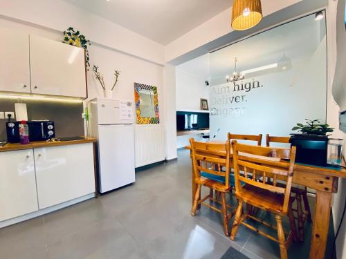 a kitchen with a table and chairs and a refrigerator at Small Gem Studio Athens, next to metro nomismatokopeio in Athens