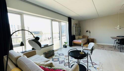 a living room with a couch and a large window at ApartmentInCopenhagen Apartment 1487 in Copenhagen