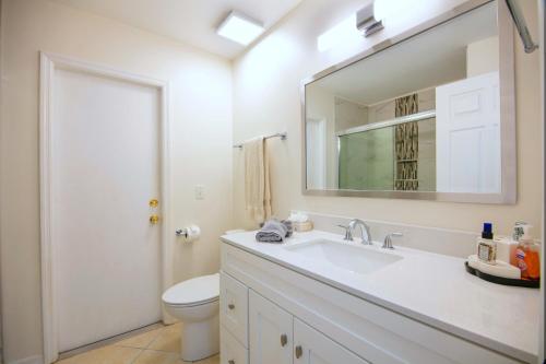 a bathroom with a sink and a toilet and a mirror at !NEW! Villa Violina in Cape Coral
