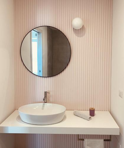 a bathroom with a white sink and a mirror at Boutique Lungomare in Porto Torres