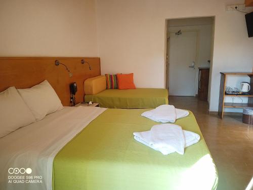 a hotel room with two beds with towels on them at Valais Hotel in Alikanas