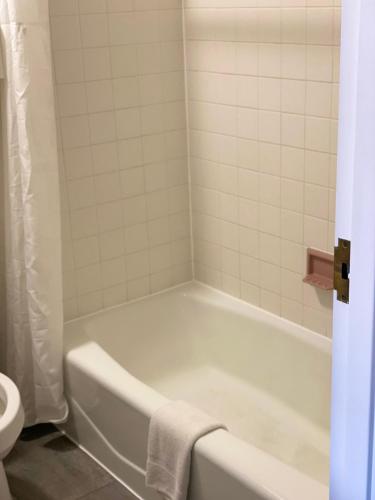 a bathroom with a white tub and a toilet at White Rose Motel - Hershey in Hershey