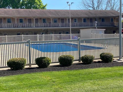 uma cerca branca com uma piscina em frente a uma casa em White Rose Motel - Hershey em Hershey