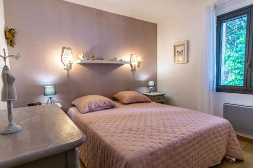 une chambre avec un grand lit et une fenêtre dans l'établissement Le Jasmin - piscine privée, à Cavaillon