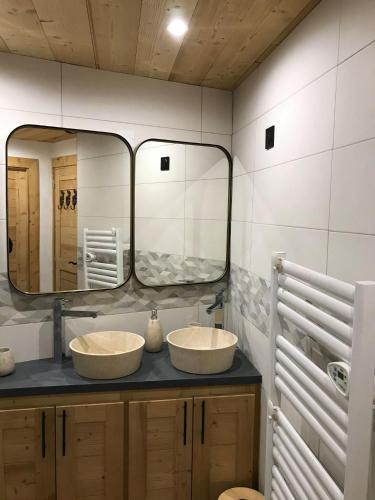 a bathroom with two sinks and a large mirror at Cocoonabay Appartements in Les Angles