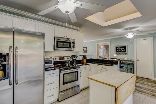 a kitchen with white cabinets and a stainless steel refrigerator at 30 22nd Ave in Isle of Palms