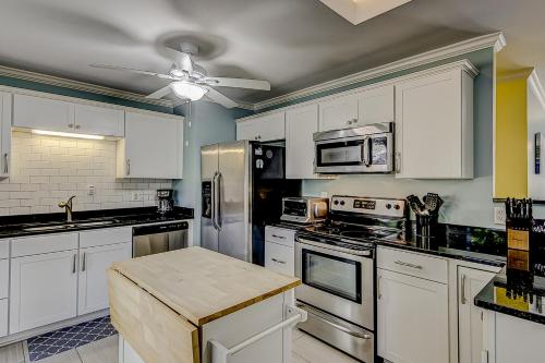 a kitchen with white cabinets and stainless steel appliances at 30 22nd Ave in Isle of Palms