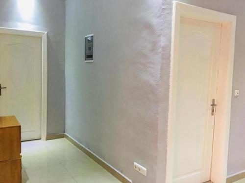 a room with a white wall and a door at Villa Cocotiers A11 in Cotonou