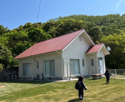 two children walking in front of a house at Holiday Villa 旅生 in Tonosho