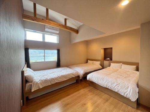 two beds in a room with a window at Koya TRIBE - Vacation STAY 48392v in Oishi
