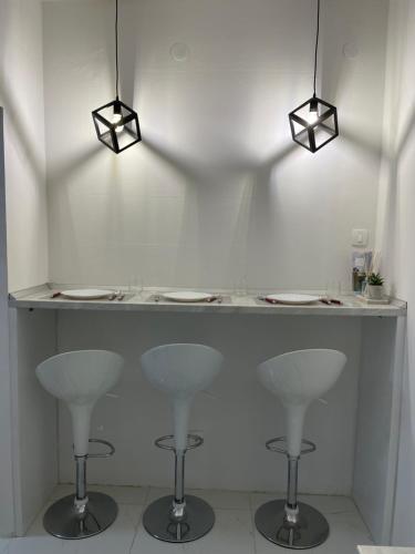 a white counter with two stools and two lights at Modern & cozy 2-bedroom vacation home in Sarajevo in Sarajevo