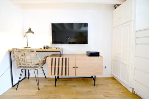 une pièce avec un bureau, une chaise et une télévision dans l'établissement HELDER Cozy Studio in Hyper-center, à Biarritz
