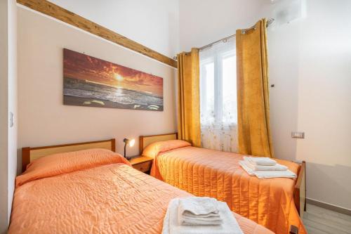 une chambre avec deux lits et une fenêtre dans l'établissement Casa Helen, à SantʼAntìoco