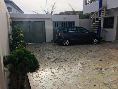 a black car parked in front of a garage at Villa Cocotiers A11 in Cotonou