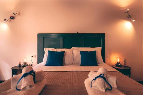 a bedroom with a large bed with blue pillows at Lo Speziale - Ginepro in Sirolo