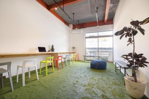 a room with chairs and a bar with a plant at Coliving & Cafe SANDO - Vacation STAY 26481v in Imabari