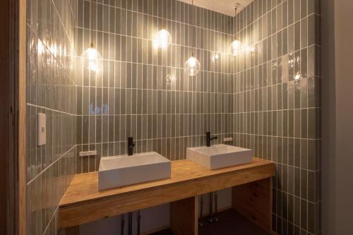 a bathroom with two sinks on a wooden counter with lights at Coliving & Cafe SANDO - Vacation STAY 27354v in Imabari
