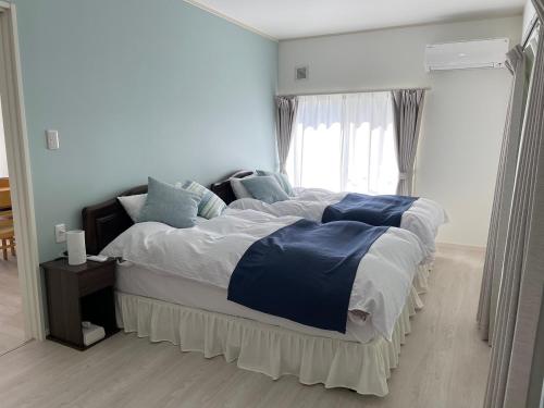 Schlafzimmer mit einem großen Bett und einem Fenster in der Unterkunft Holiday Villa 旅生 in Tonosho