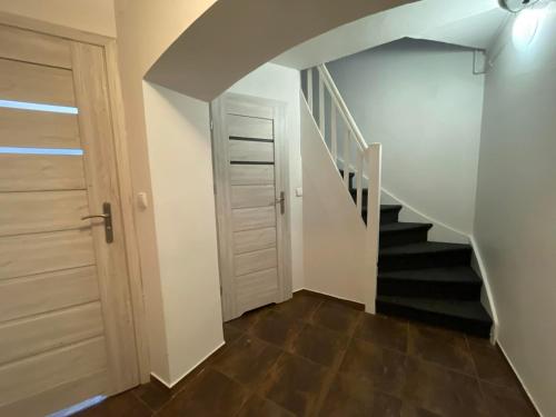a hallway with a staircase with a door and a stair case at Pokoje we Wrzeszczu (Gdańsk) in Gdańsk