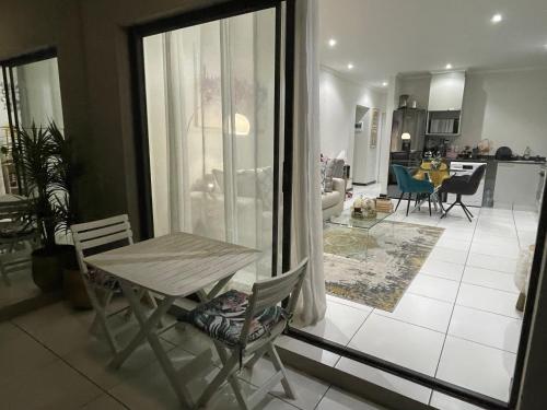 a dining room and living room with a table and chairs at Fourways Luxe Suite in Sandton
