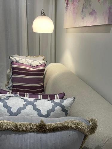 a bedroom with a couch with a pillow and a lamp at Fourways Luxe Suite in Sandton