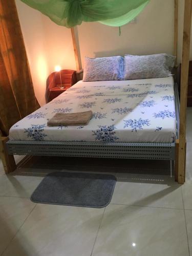 a bedroom with a bed with blue flowers on it at Villa Cocotiers A11 in Cotonou