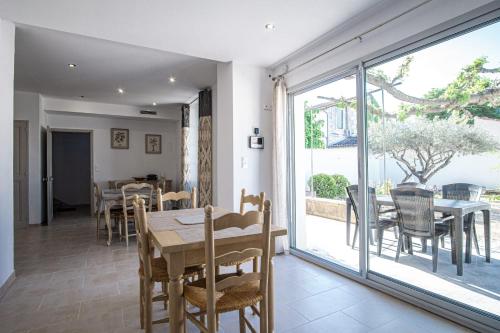 une salle à manger avec une table et des chaises dans l'établissement Maison avec jardin proche du centre-ville Isle-sur-la-Sorgue, à LʼIsle-sur-la-Sorgue