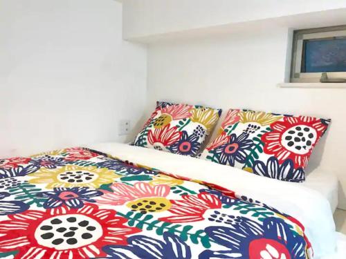 - un lit avec des draps et des oreillers colorés dans l'établissement KIKO HOUSE - Vacation STAY 42460v, à Tokyo