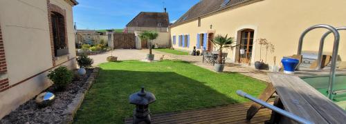 a backyard with a yard of green grass at Gîte au cœur des vignes avec piscine et spa in Saudoy