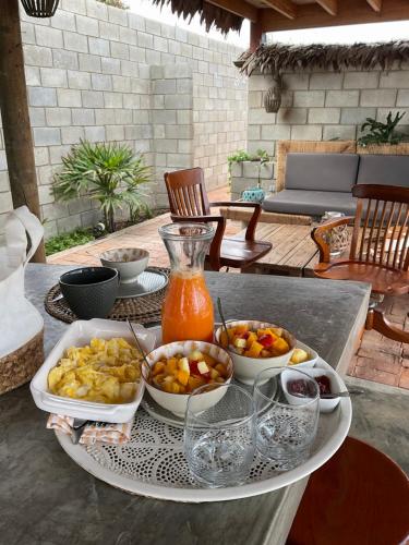 a table with bowls of food and a pitcher of juice at OPALO Casa de Mar in Canoas De Punta Sal