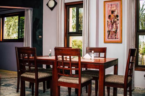 uma sala de jantar com uma mesa de madeira e cadeiras em Résidence Hôtelière Lauria em Lomé