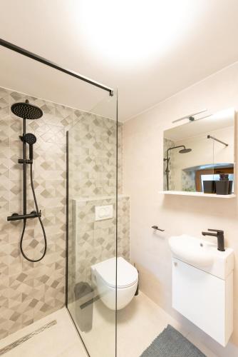 a bathroom with a shower and a toilet and a sink at Apartment Olive in Kaštela