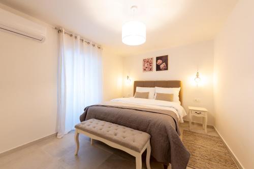a bedroom with a bed with a bench next to it at Apartment Olive in Kaštela