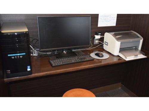 a desk with a computer monitor and a printer at Hotel RESH Tottori Ekimae - Vacation STAY 47411v in Tottori