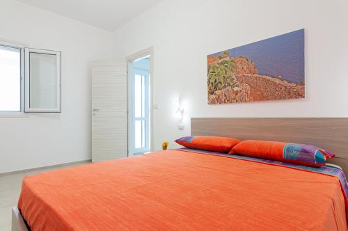 um quarto com uma grande cama laranja e 2 almofadas em Villa Marisa Holiday Home em Punta Prosciutto