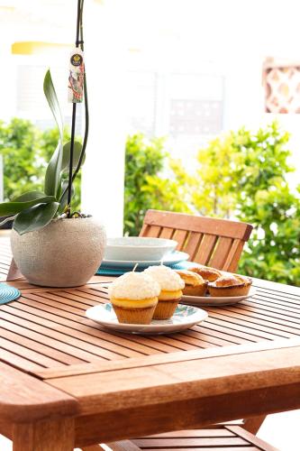 a wooden table with plates of muffins on it at Villa Marisa Holiday Home in Punta Prosciutto