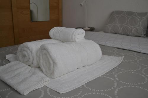 een stapel handdoeken bovenop een bed bij Charming House in Triana,best City View from Patio in Sevilla
