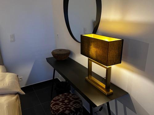 a room with a table with a mirror and a lamp at Maison Gand in Ghent