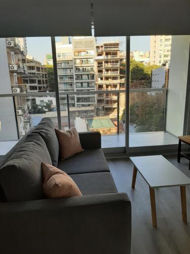 sala de estar con sofá y ventana grande en Departamento Bulnes en Buenos Aires