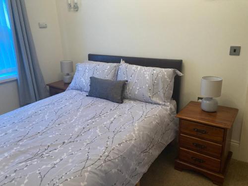 a bedroom with a bed and a nightstand with two lamps at Apartment 8 The Landings in Filey